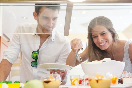 un hombre y una mujer están mirando comida en un mostrador
