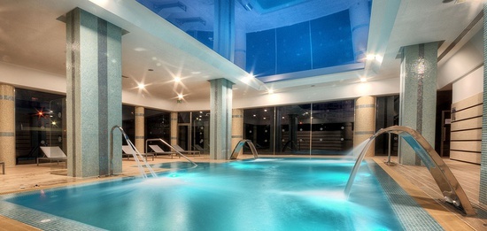 a large indoor swimming pool with a blue ceiling