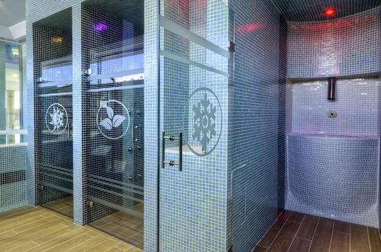 a bathroom with blue tiles and a glass shower