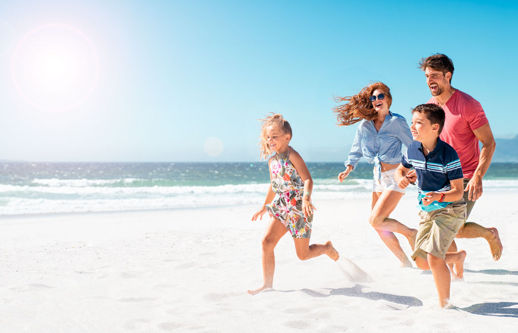 una familia corre por la playa en un día soleado