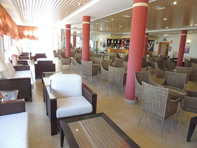 una sala de estar con muchas sillas y mesas - 