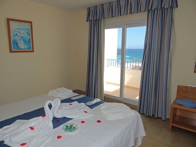 a bedroom with a sliding glass door and a picture of dolphins on the wall