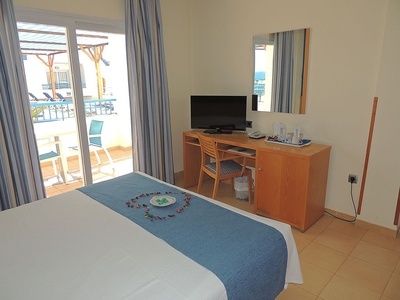 a hotel room with a desk and a flat screen tv