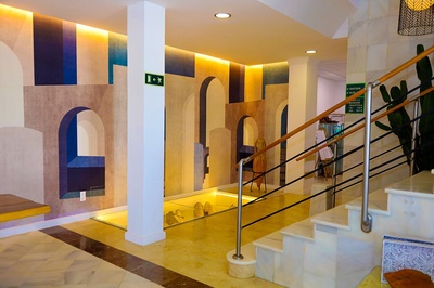 Entrada moderna del Hotel El Puntazo con mural artístico y escaleras de mármol. - 