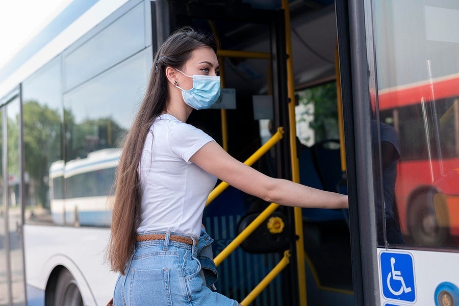 una mujer con una máscara se sube a un autobús