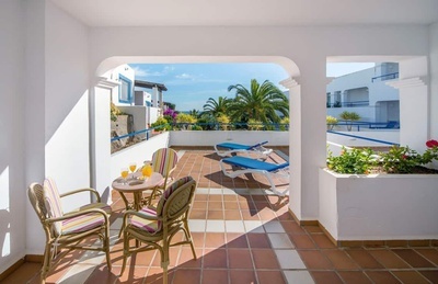 a balcony with a table and chairs and a blue lounge chair