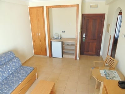 a hotel room with a fridge and a door that says exit