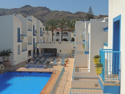 una piscina rodeada de edificios blancos y azules - 