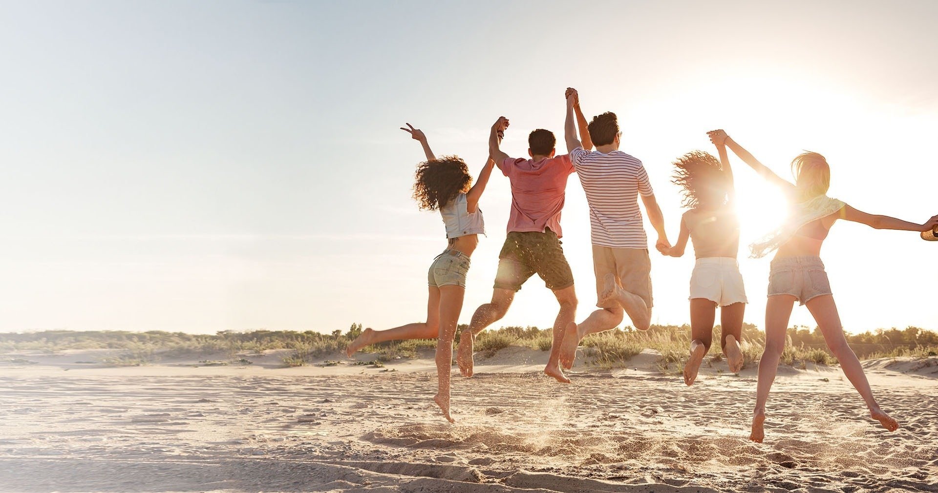  a group of people jumping in the air on a beach