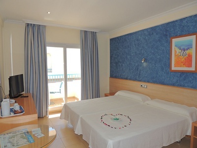 a hotel room with two beds and a picture of a fish on the wall