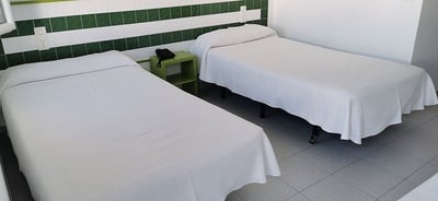 two beds in a room with green and white tiles