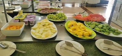 varios platos de frutas y yogures en un buffet - 