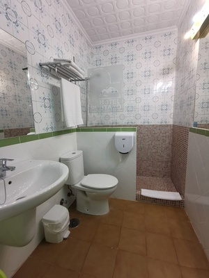 un baño con un inodoro y un lavabo y una puerta que dice hotel