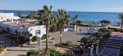 a white car is parked in a parking lot near the ocean