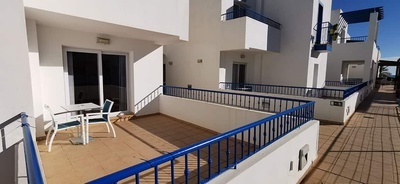 a balcony with a blue railing and a table and chairs