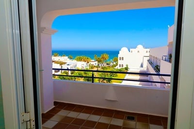 Vista al mar desde el balcón del Hotel El Puntazo, con arquitectura blanca y palmeras. - 