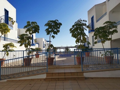 escaleras que conducen a una piscina rodeada de edificios blancos y azules