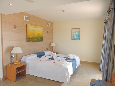 a hotel room with a painting on the wall above the bed