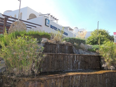una cascada se encuentra frente a un hotel blanco - 