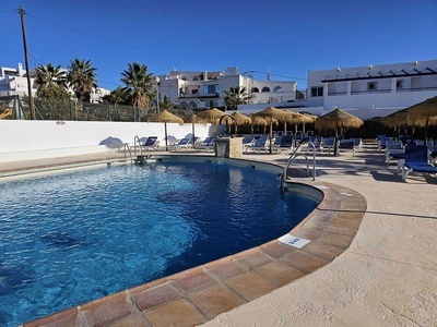 una piscina rodeada de sillas y sombrillas y un letrero que dice " no nadar " - 