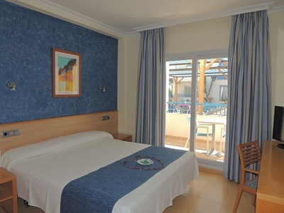 a hotel room with a bed and a picture on the wall