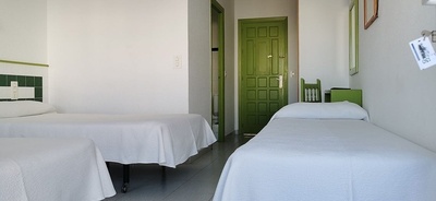 a hotel room with two beds and a green door