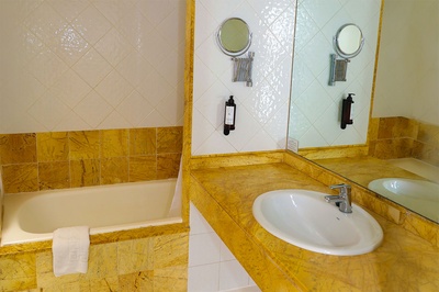 Baño en El Puntazo con bañera y lavabo sobre encimera de mármol. - 