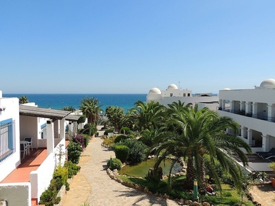 a white building with a balcony overlooking the ocean