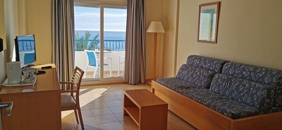 a living room with a couch a desk and a television