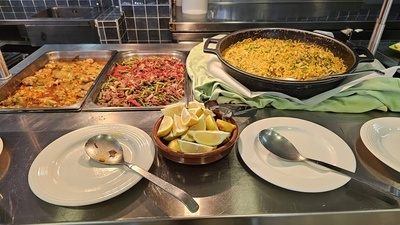 un buffet con platos y cucharas y una sartén de arroz - 