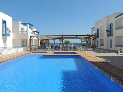 una piscina rodeada de edificios blancos y azules - 