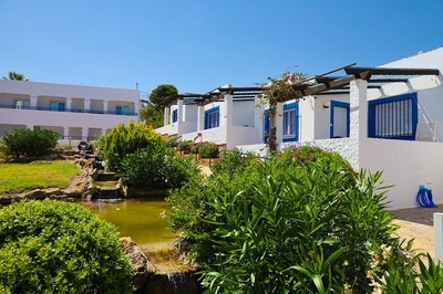Villas blancas con ventanas azules en El Puntazo, con estanque y vegetación exuberante. - 