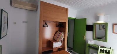 una habitación con una puerta verde y un espejo