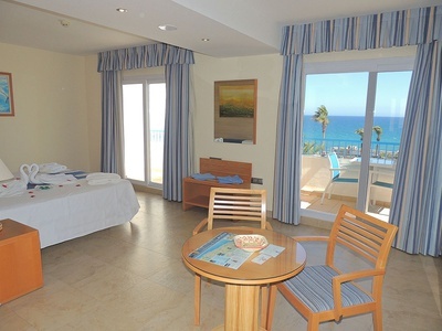 a hotel room with a table and chairs and a view of the ocean