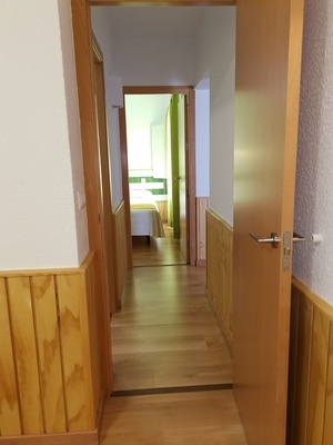 a hallway leading to a bedroom with wood paneling