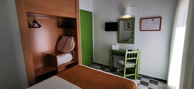 una habitación con una cama y una silla verde