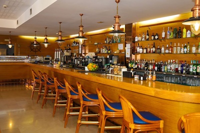 Bar del Hotel El Puntazo: asientos, botellas de licor y decoración náutica. - 