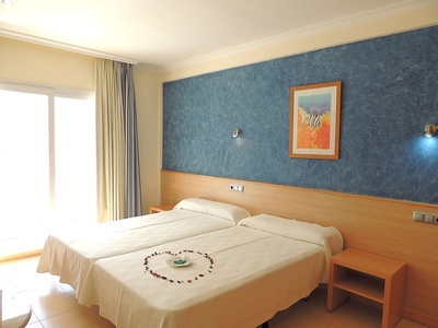 a hotel room with two beds and a picture on the wall