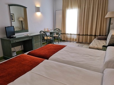 a hotel room with two beds a table and chairs