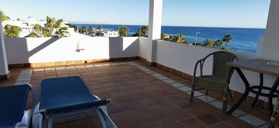 una terraza con sillas y una mesa con vistas al océano