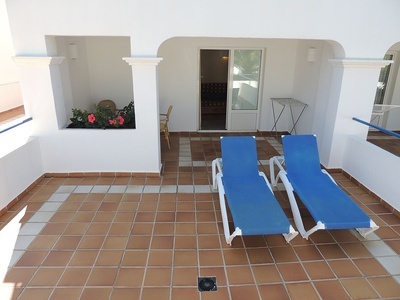 dos tumbonas azules están sentadas en una terraza de baldosas - 