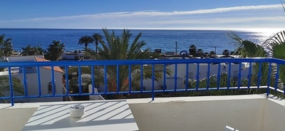 a view of the ocean from a balcony with a blue railing
