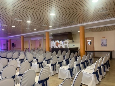 una sala llena de sillas blancas y azules con la palabra acar en el fondo - 