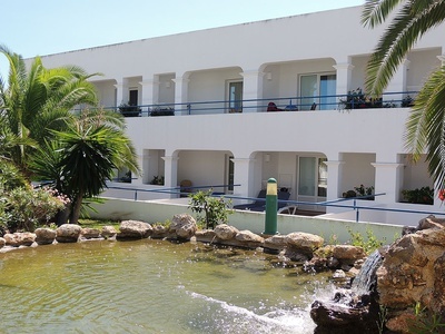 un edificio blanco con balcones y una cascada - 