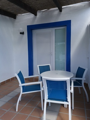 a white table with blue chairs in front of a door