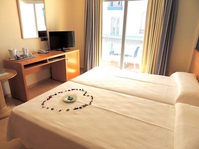 a hotel room with two beds and a flat screen tv