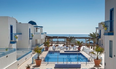 una piscina rodeada de edificios blancos y azules con vistas al océano