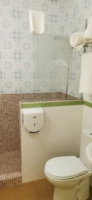 a bathroom with a toilet and a paper towel dispenser