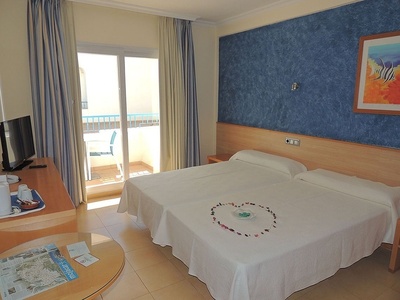 a hotel room with two beds and a blue wall