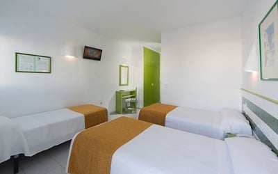 a hotel room with two beds and a tv on the wall